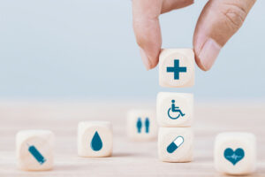 Hand chooses a emoticon icons healthcare medical symbol on woode